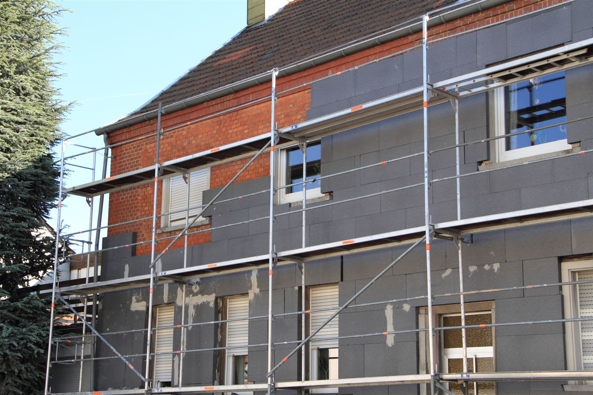 Hausfassade mit Gerüst und montierten Dämmplatten — Fassadendämmung in Rostock